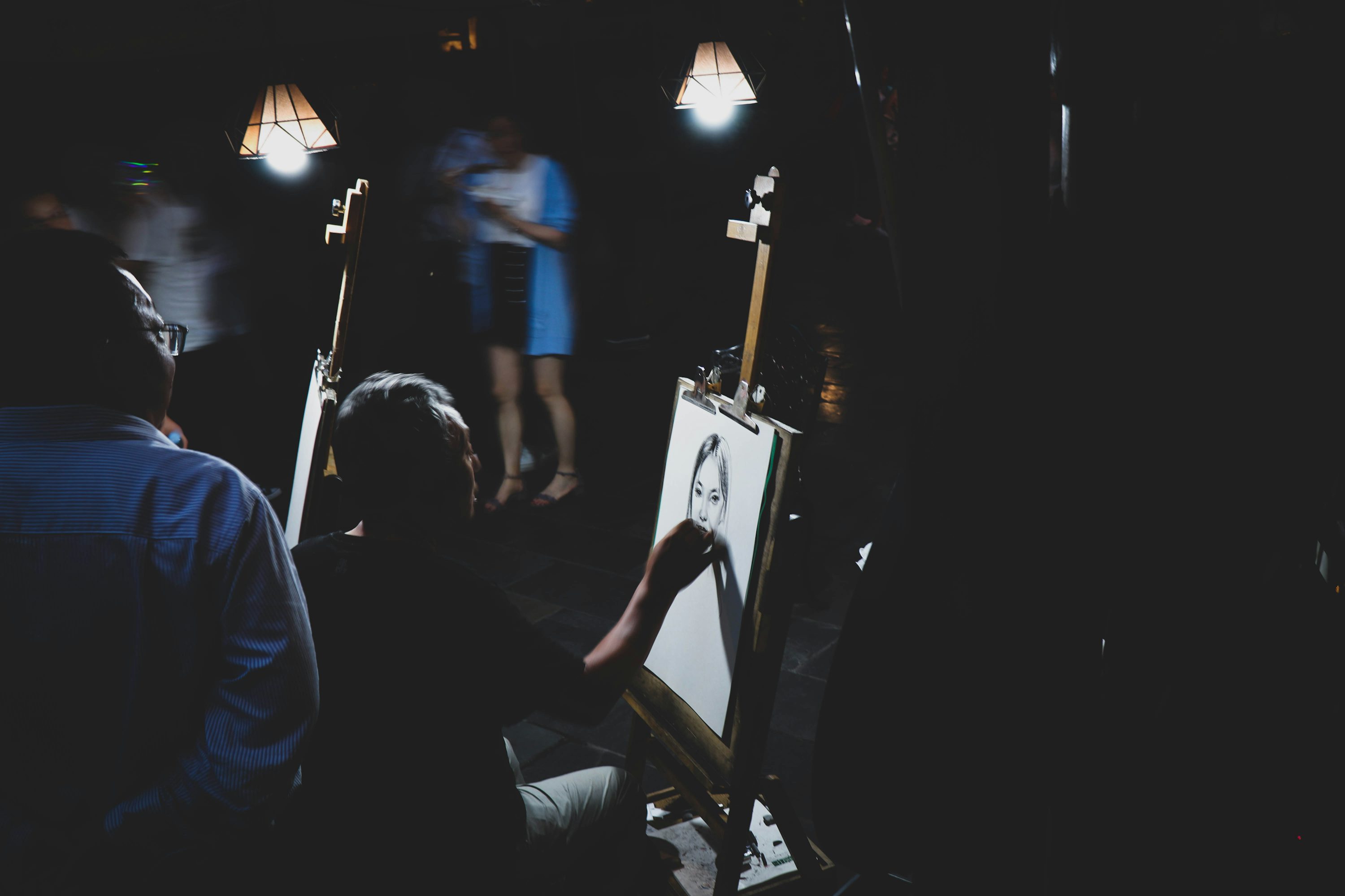 夜のランプの下で肖像画を描くアーティスト——夜型の創造性のアドバンテージ